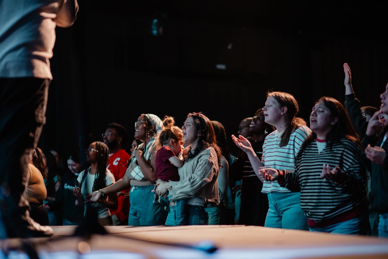 Congregation in worship with hands raised / Gwinnett