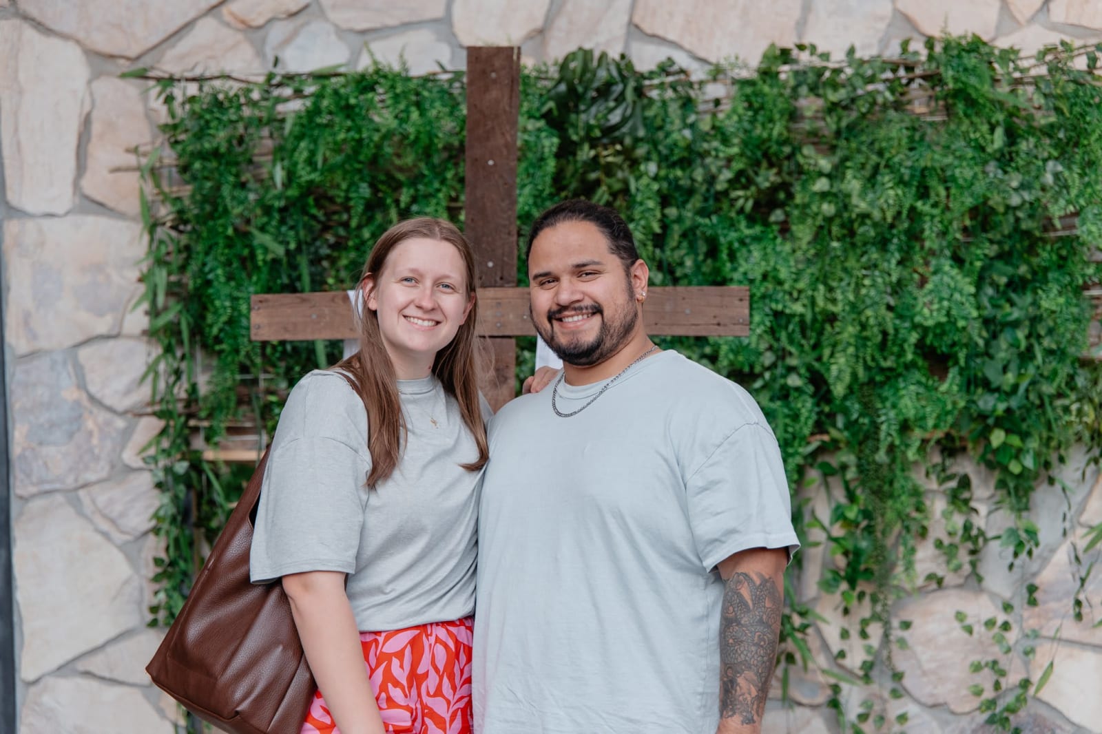 couple posed in front of cross  / gwinnett + building