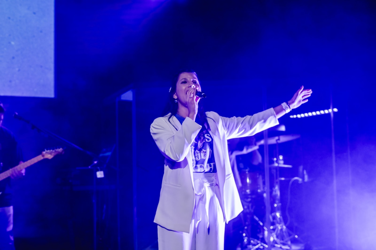 female worship singer with arm extended on stage / kennesaw