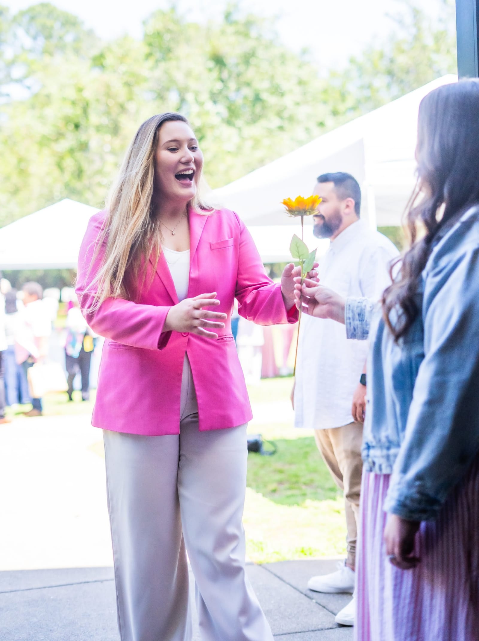 woman in pink giving sunflower outdoors / kennesaw