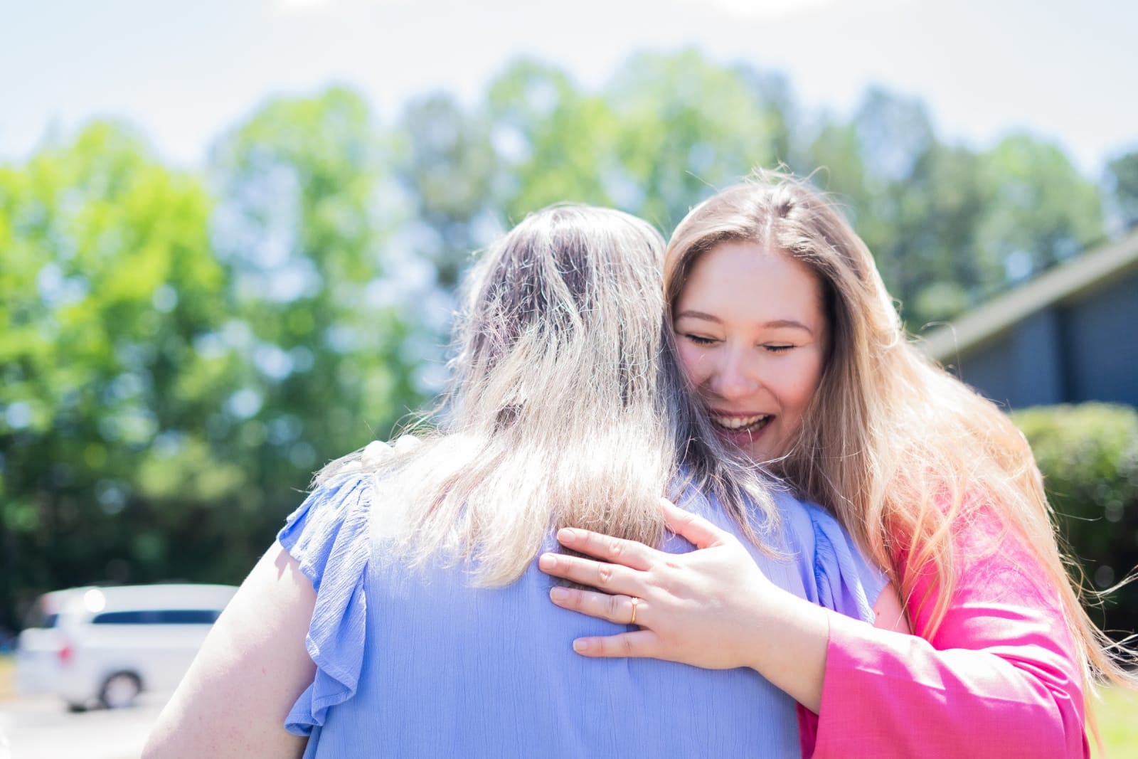 two women hugging outdoors / kennesaw