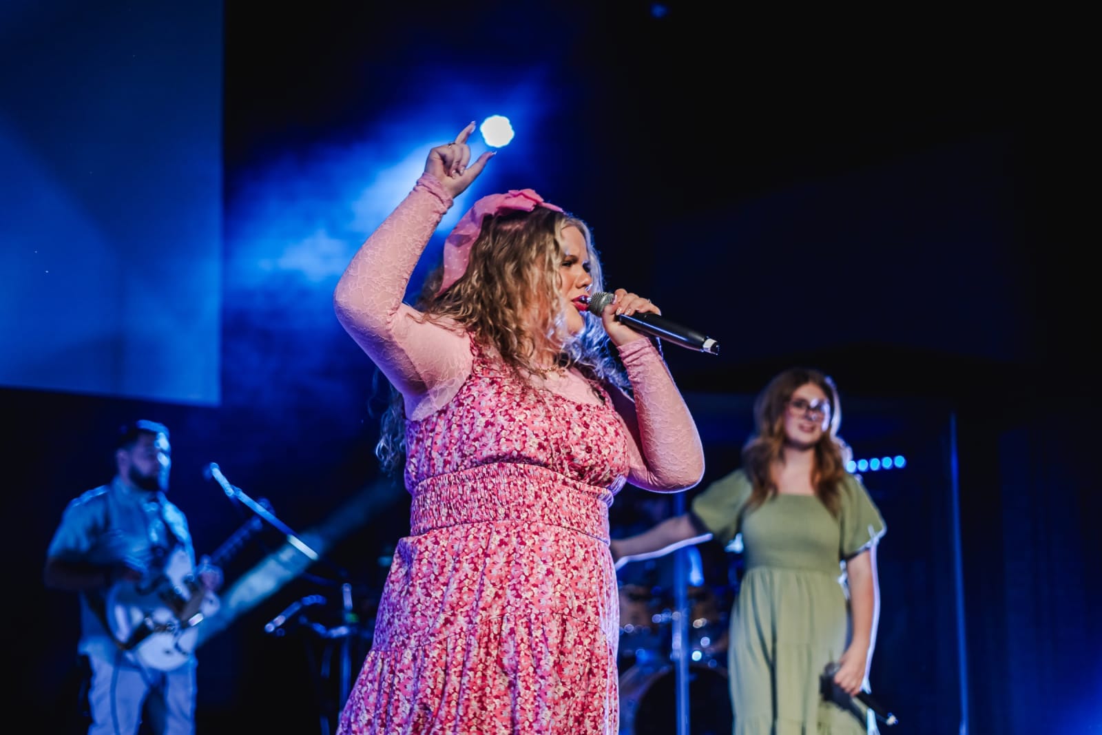 female worship singer with arm raised singing / kennesaw
