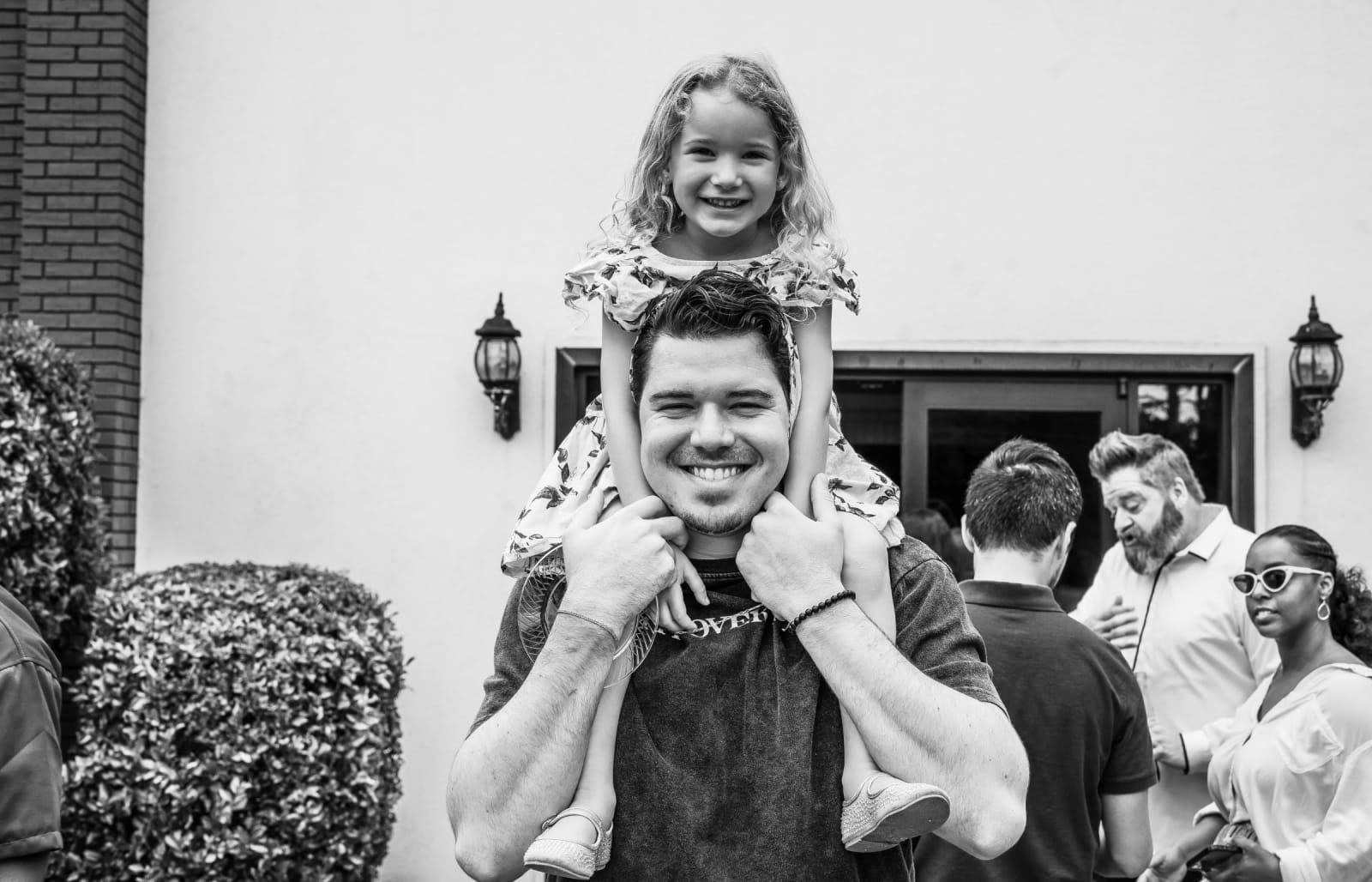 man with girl on shoulders black and white photo / kennesaw