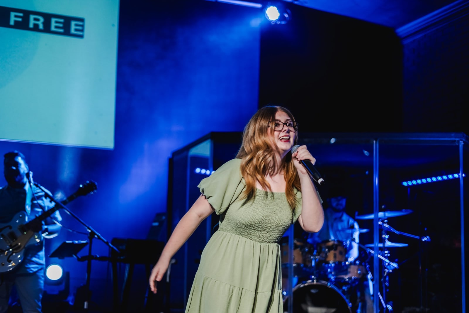 female worship leader singing on stage / kennesaw