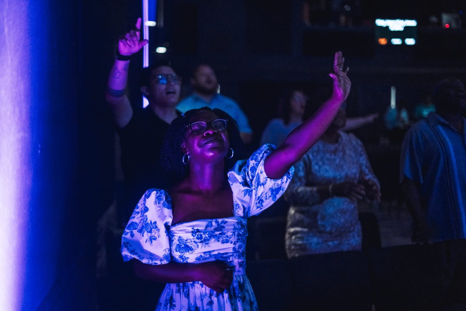 woman worshipping with hand raised / kennesaw