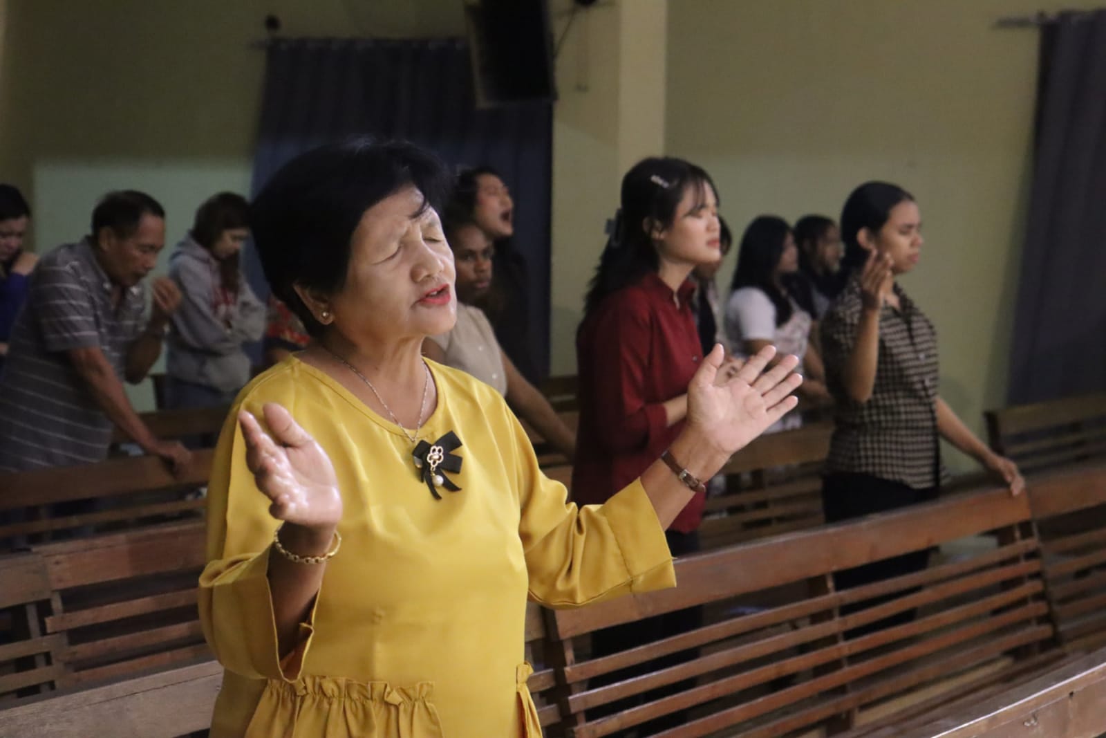 Congregation member raising hands in worship at Solo campus Futures Church service