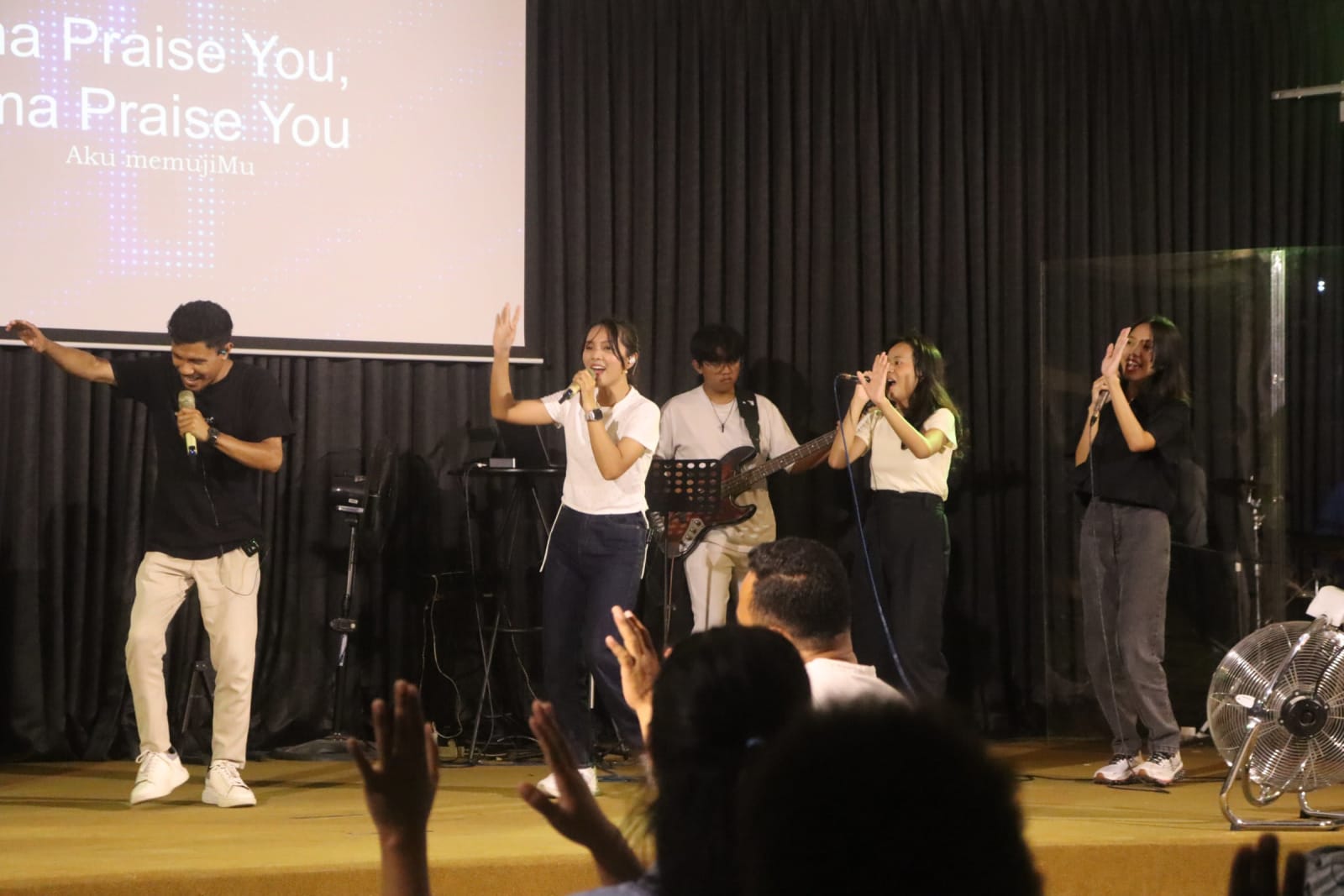 Worship leader and team on stage at Solo campus church service
