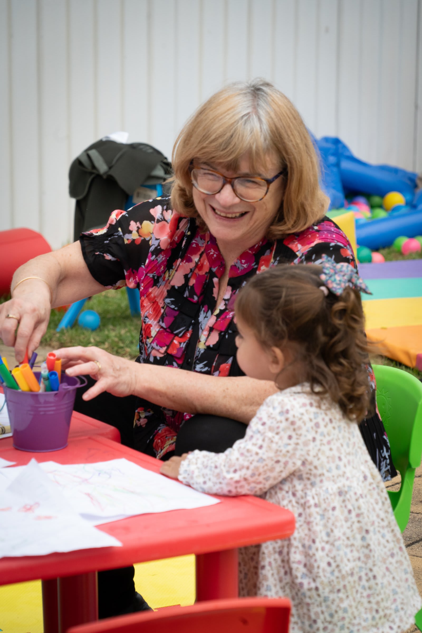 A woman helping a young girl with craft supplies / victor harbor