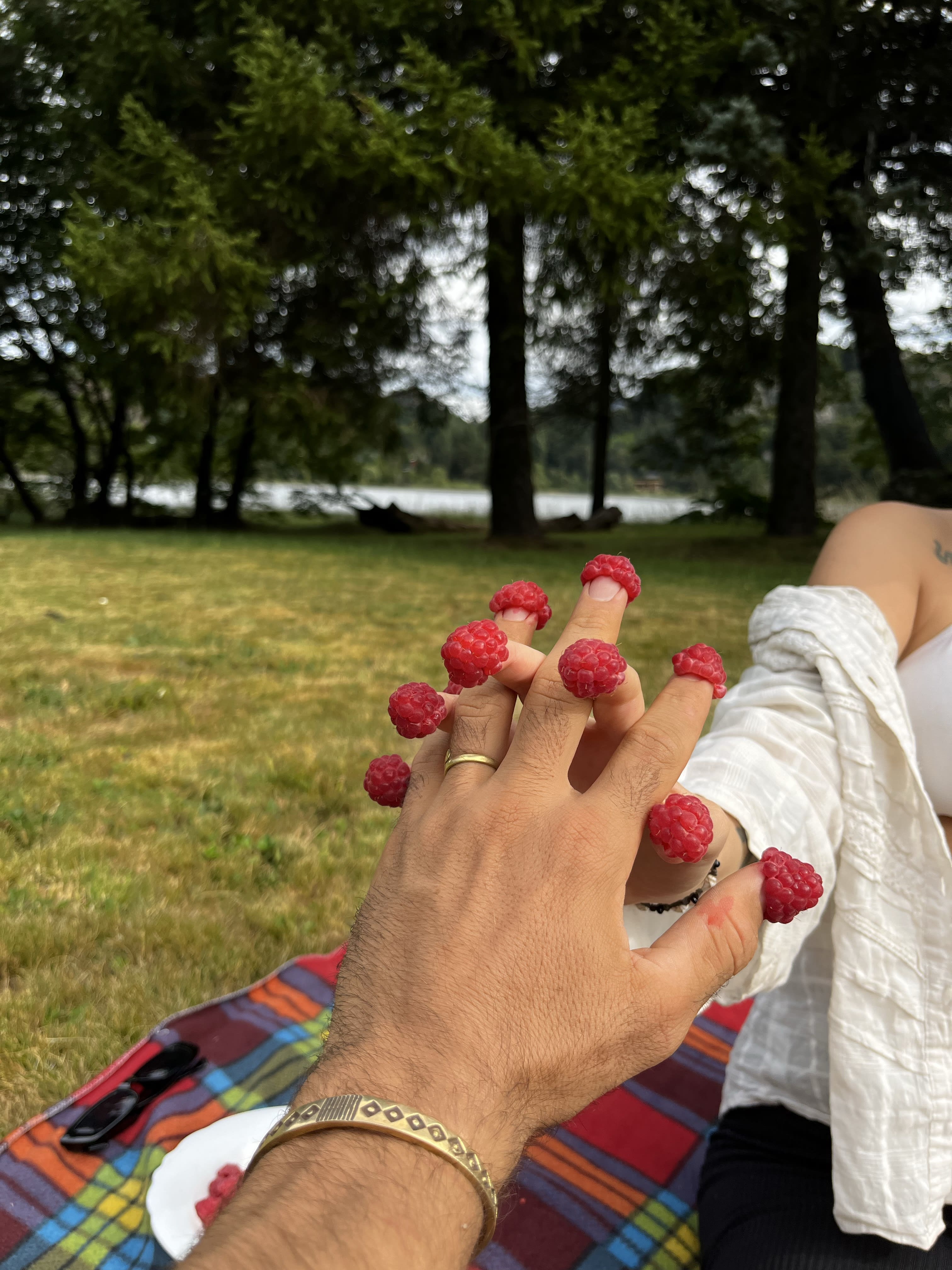 Couple holding hands with a raspberry balanced on each fingertip