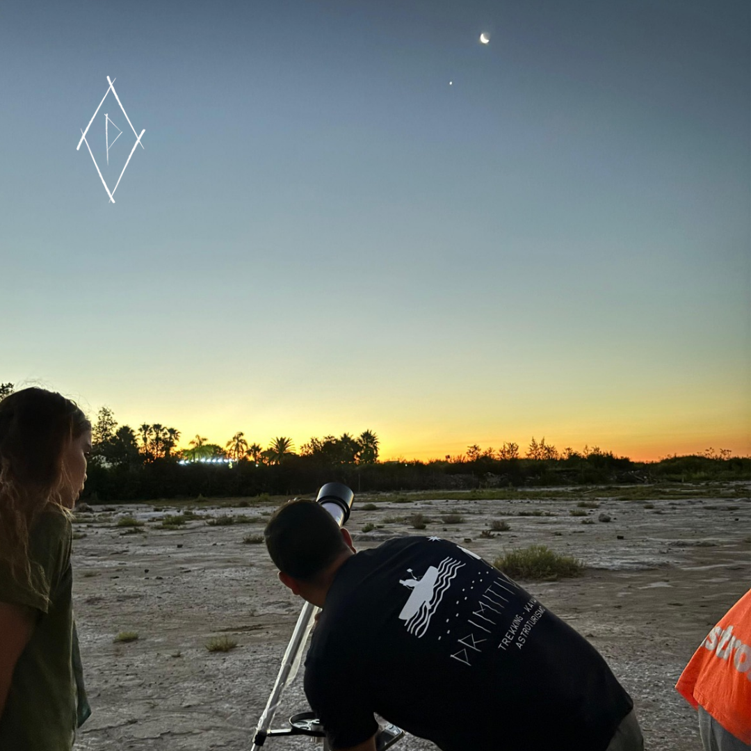 Guía local enseñado la luna a través de un telescopio a turistas.