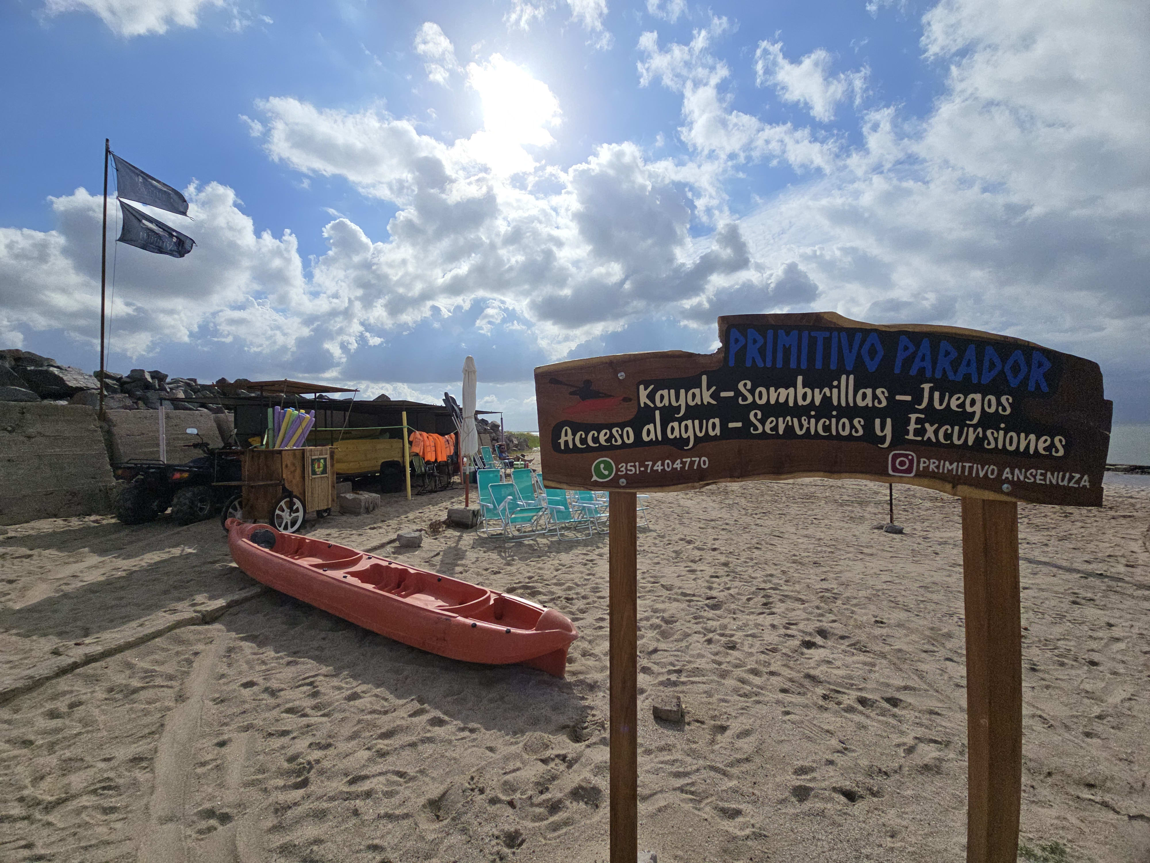 Local playero con sombrillas, kaykas y reposeras a orillas de la Laguna mar chiquita.
