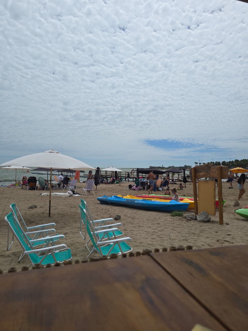 Detalles de local playero con servicio de kayaks y sombrillas en la arena.