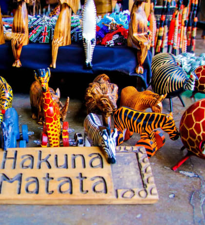 Carved animals behind a Hakuna Matata sign