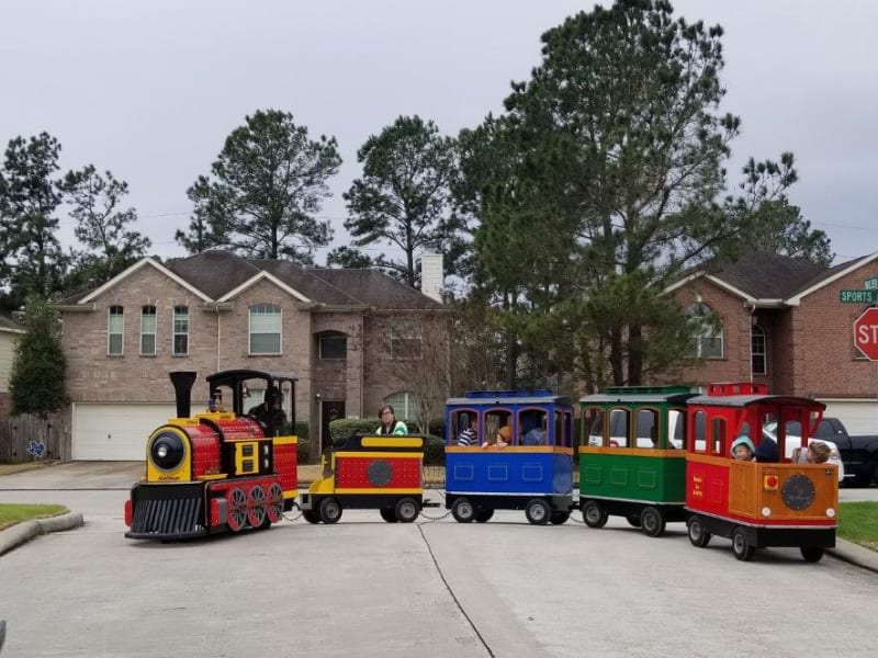 The Diamond Express trackless train carrying riders through a Houston-area neighborhood
