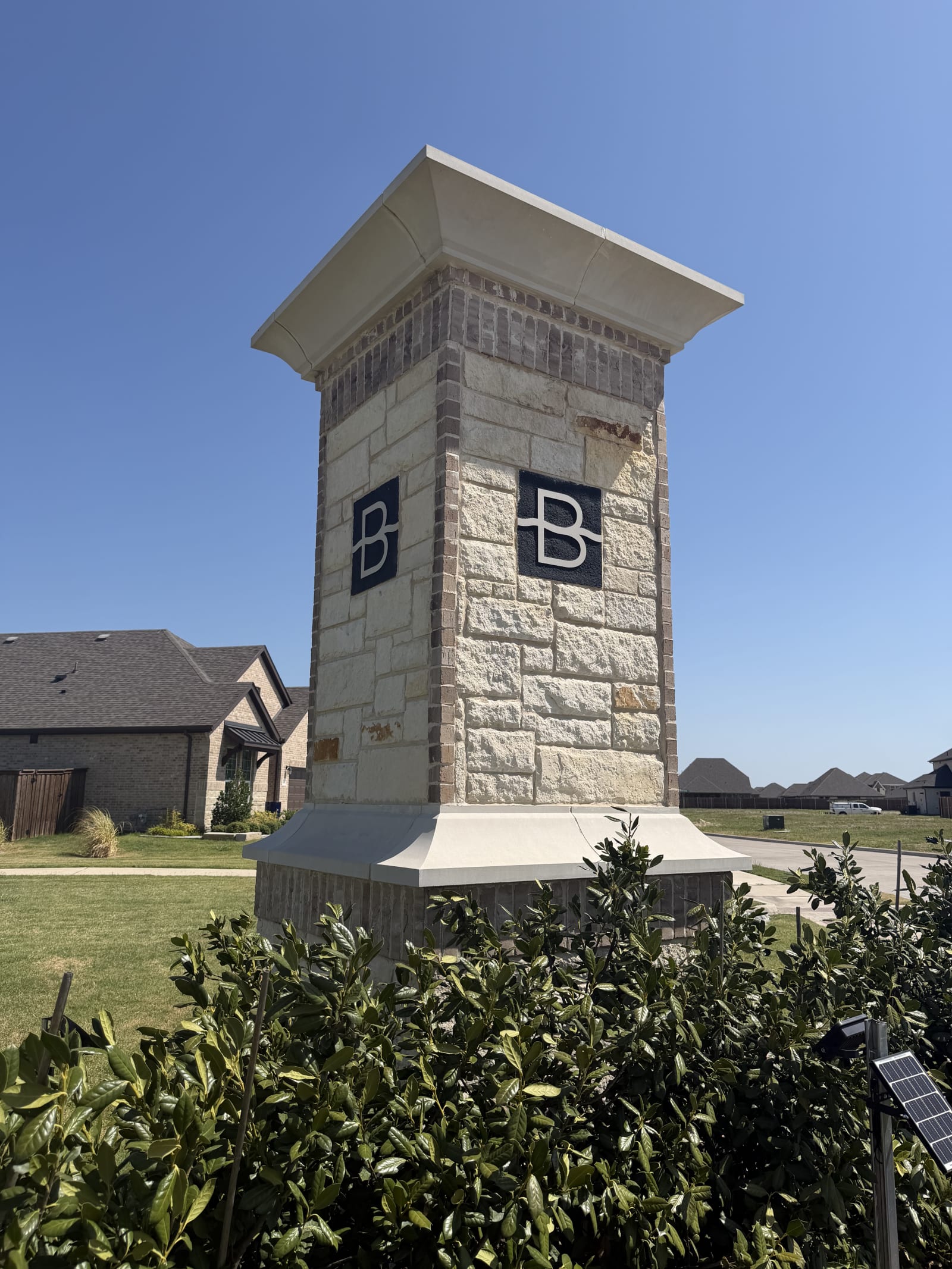 Cut stone and brick entry column with a cast cap at Brookville Estates in Forney, TX