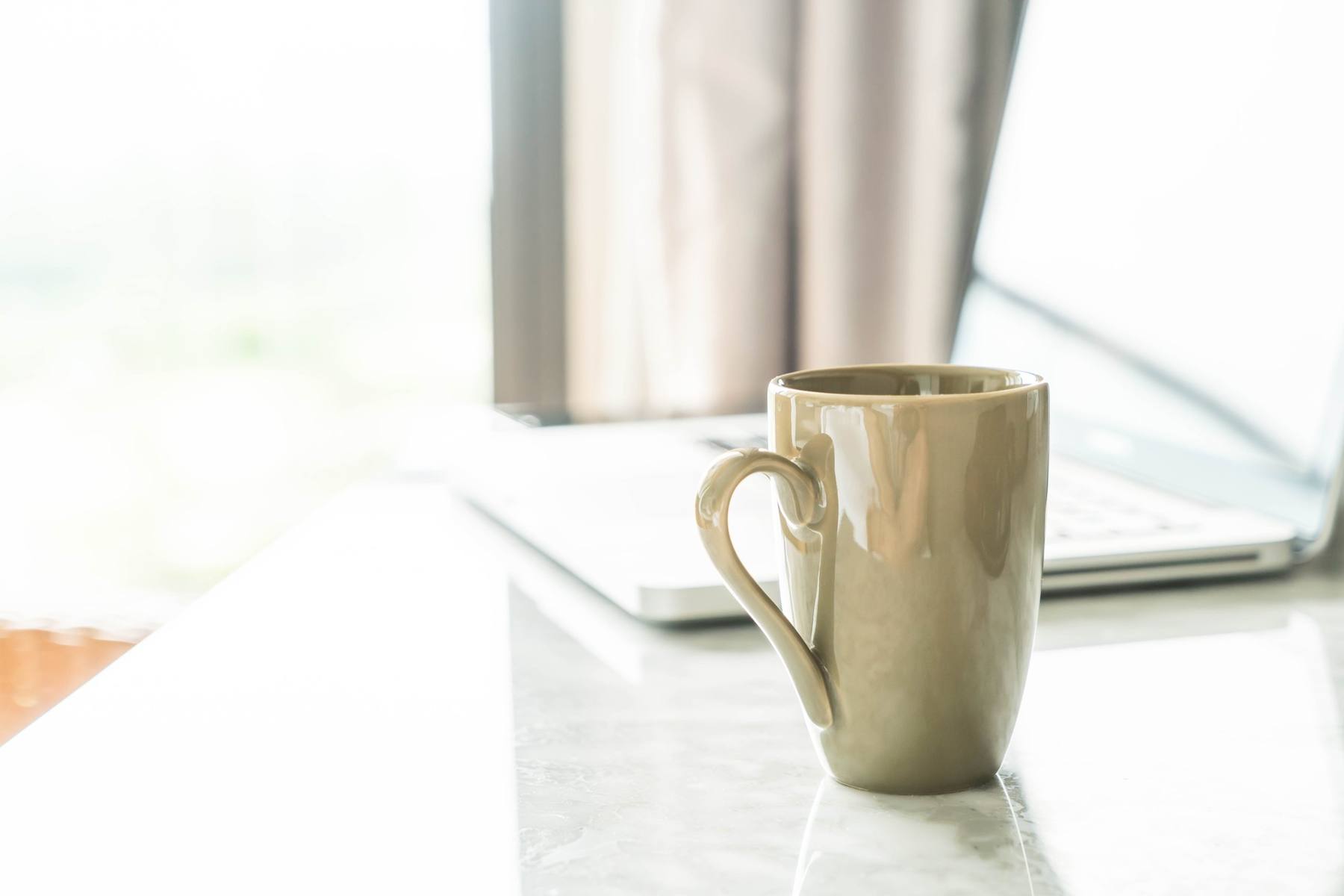 A warm mug on a sunlit table by the window
