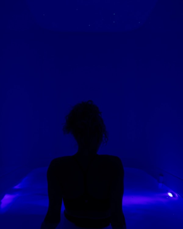 Guest settling into the float pod under blue light