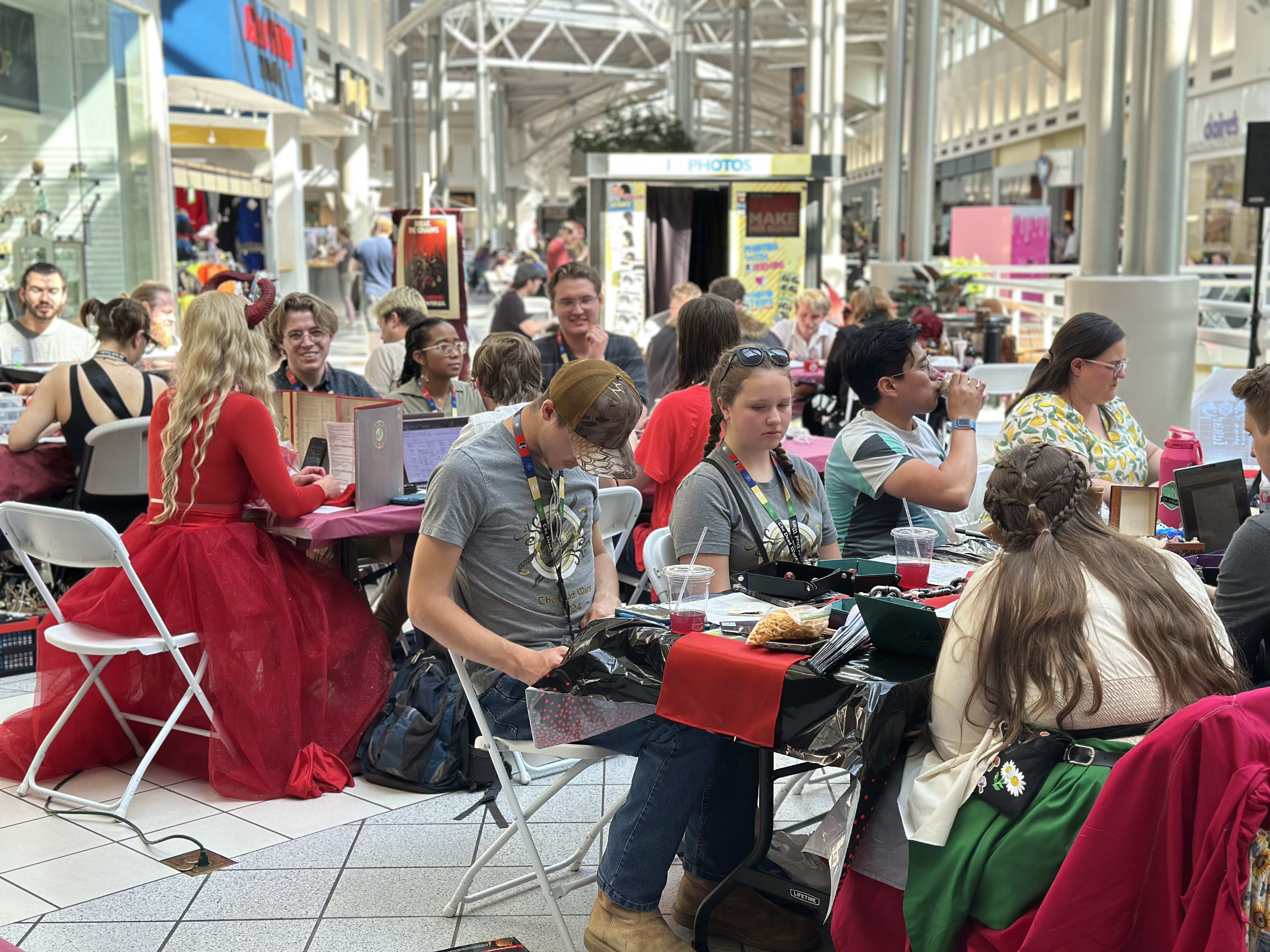 Gaming tables are grouped by faction or role, cooperating together for the common good.