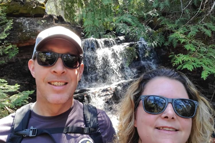 Selfie of Michelle and her husband at a smaller set of falls on Mazukama Trail