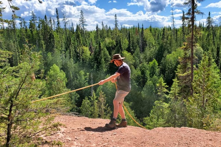 Michelle's husband about to climb down steep natural stairs with a rope