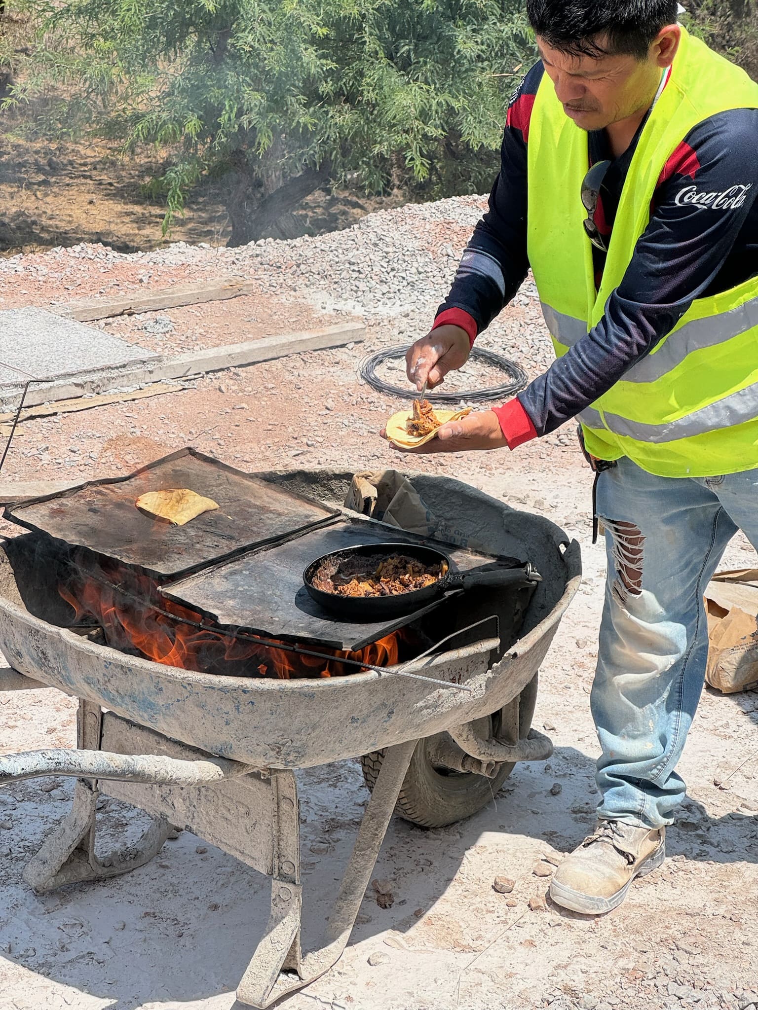 Trabajador calentando su comida en una carretilla en la construcción.