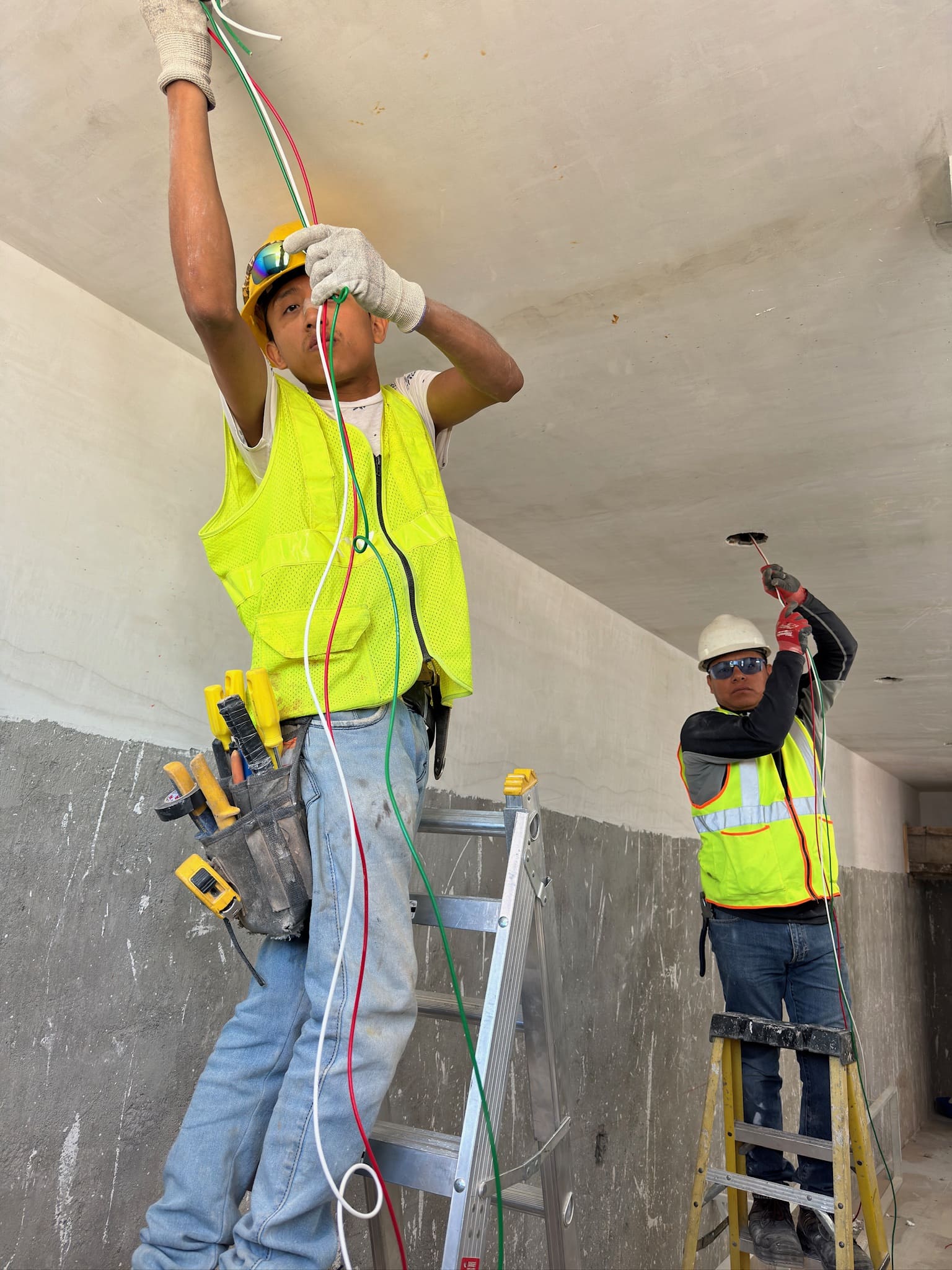 Electricistas trabajando con equipo de protección personal.