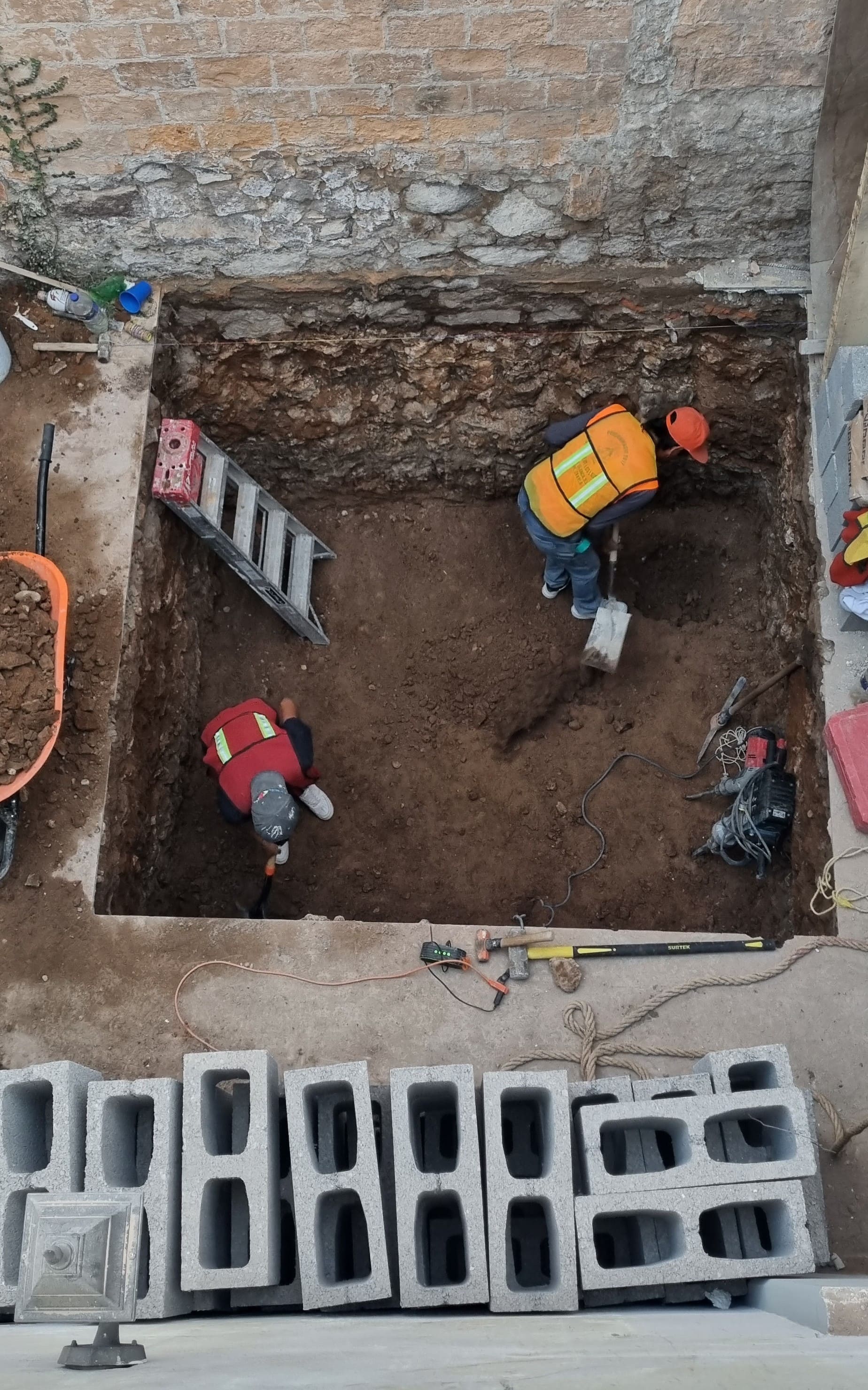 Albañiles excavando para aljibe en remodelación.