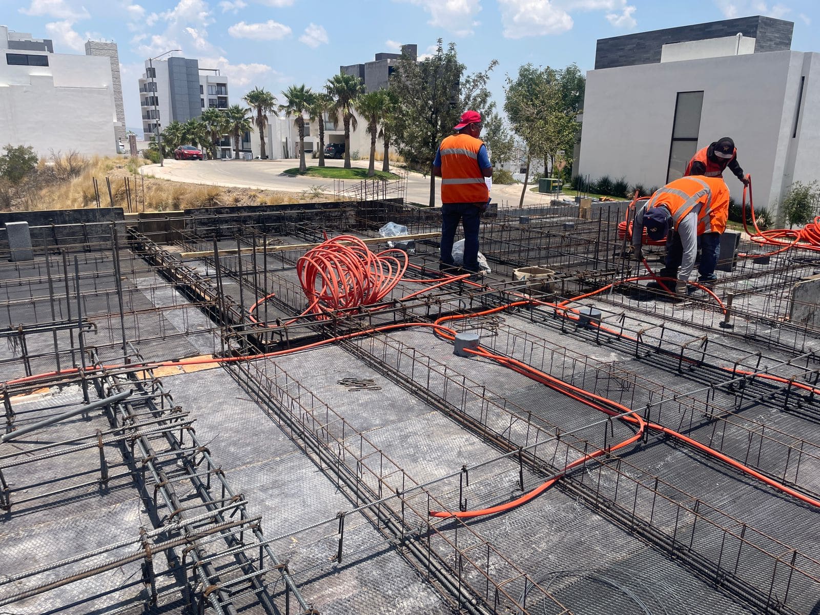 Trabajdores colocando la instalación eléctrica en una losa para exclusiva residencia.