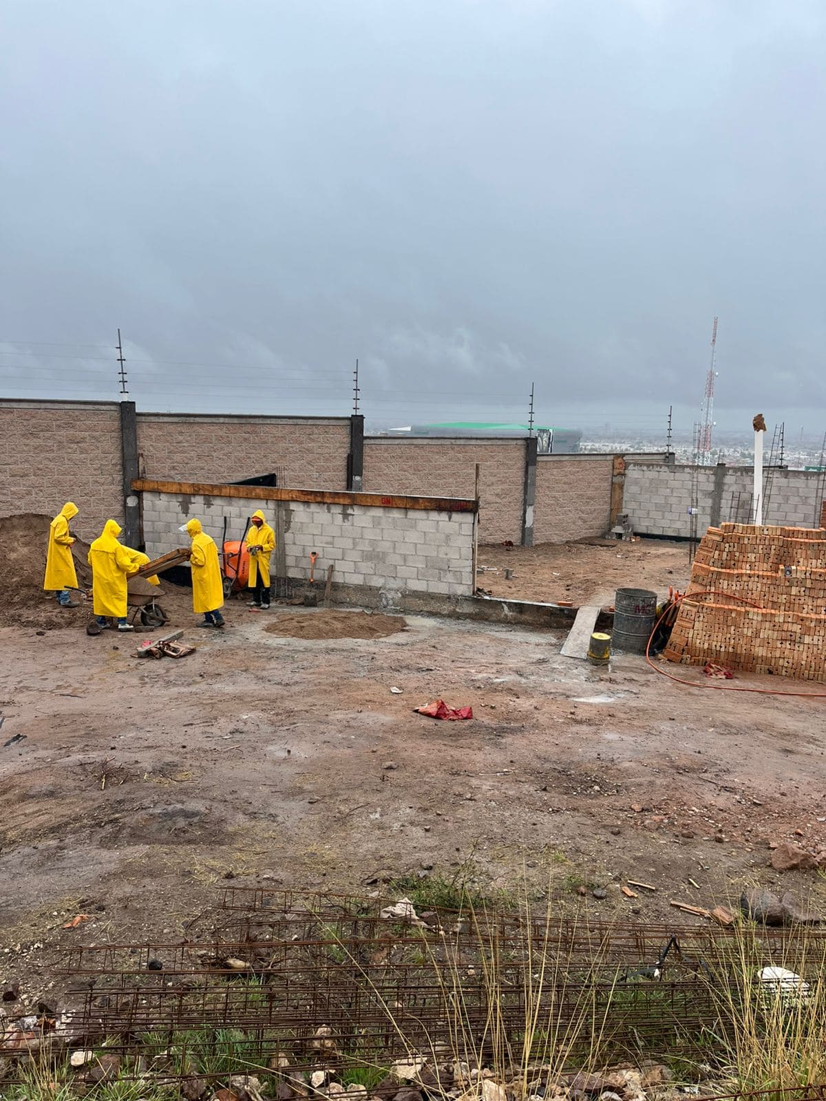 Albañiles trabajando con impermeable.