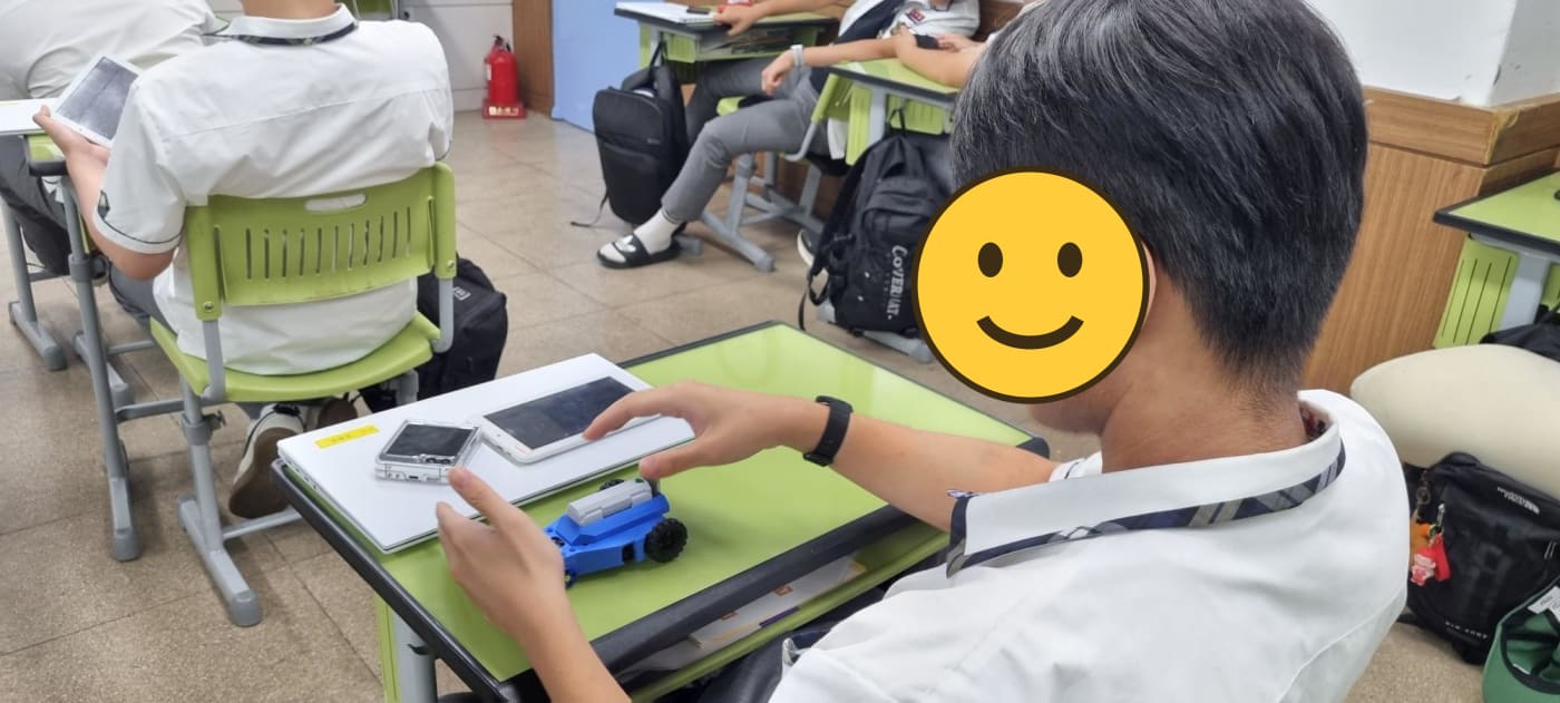 태블릿으로 로봇을 조작하는 학생