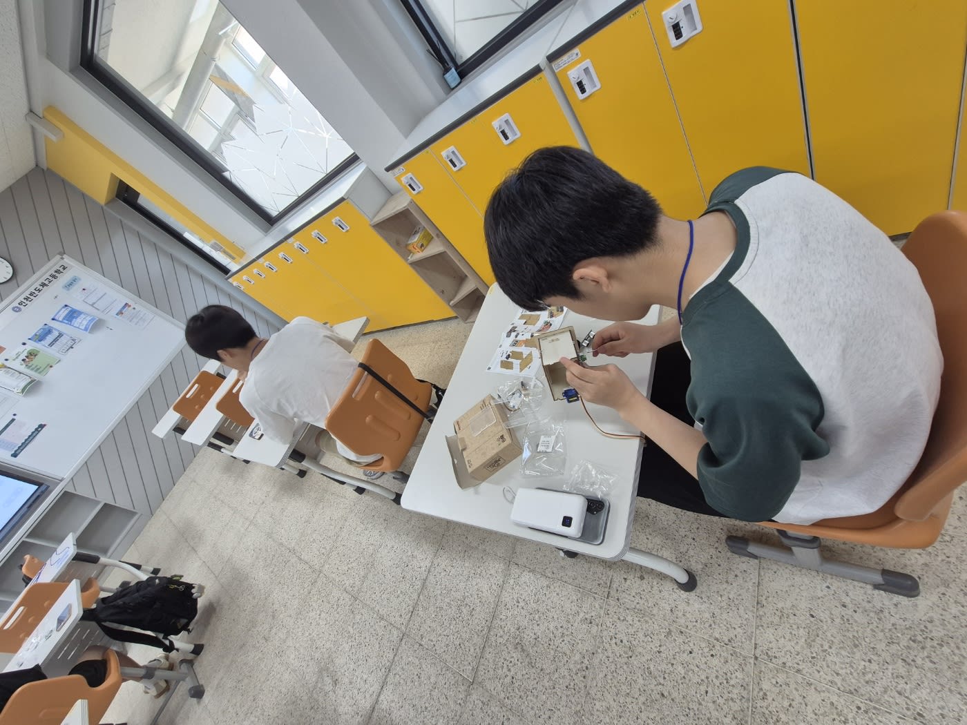 서보 모터와 센서를 조립하며 코딩 로직을 확인하는 학생들