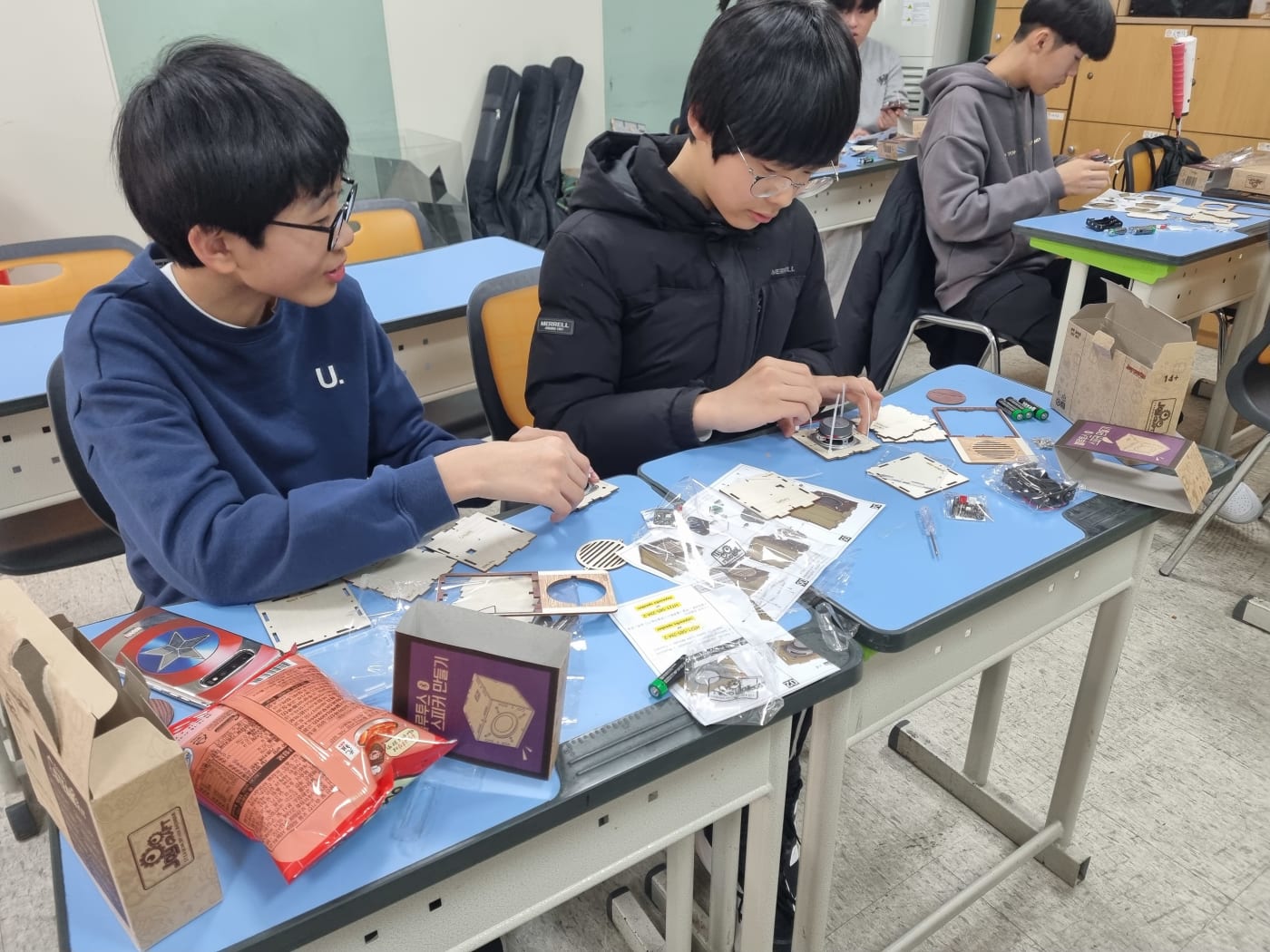친구와 함께 협력하며 스피커 내부 회로를 연결하는 모습