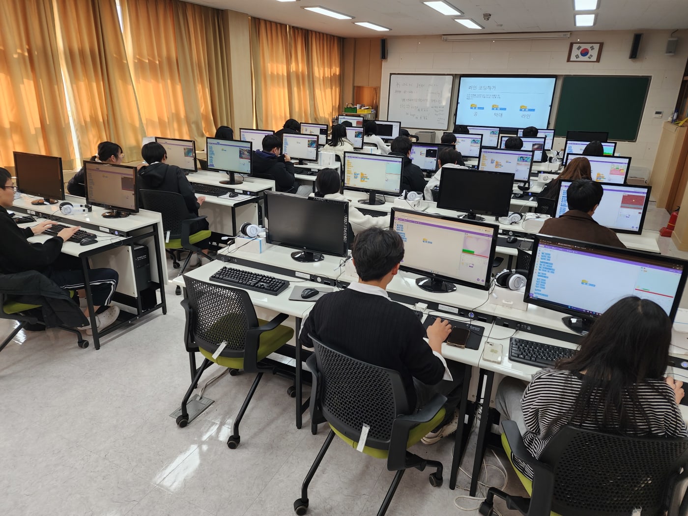 자신이 만든 게임에 대해 친구들 앞에서 발표하고 있는 학생