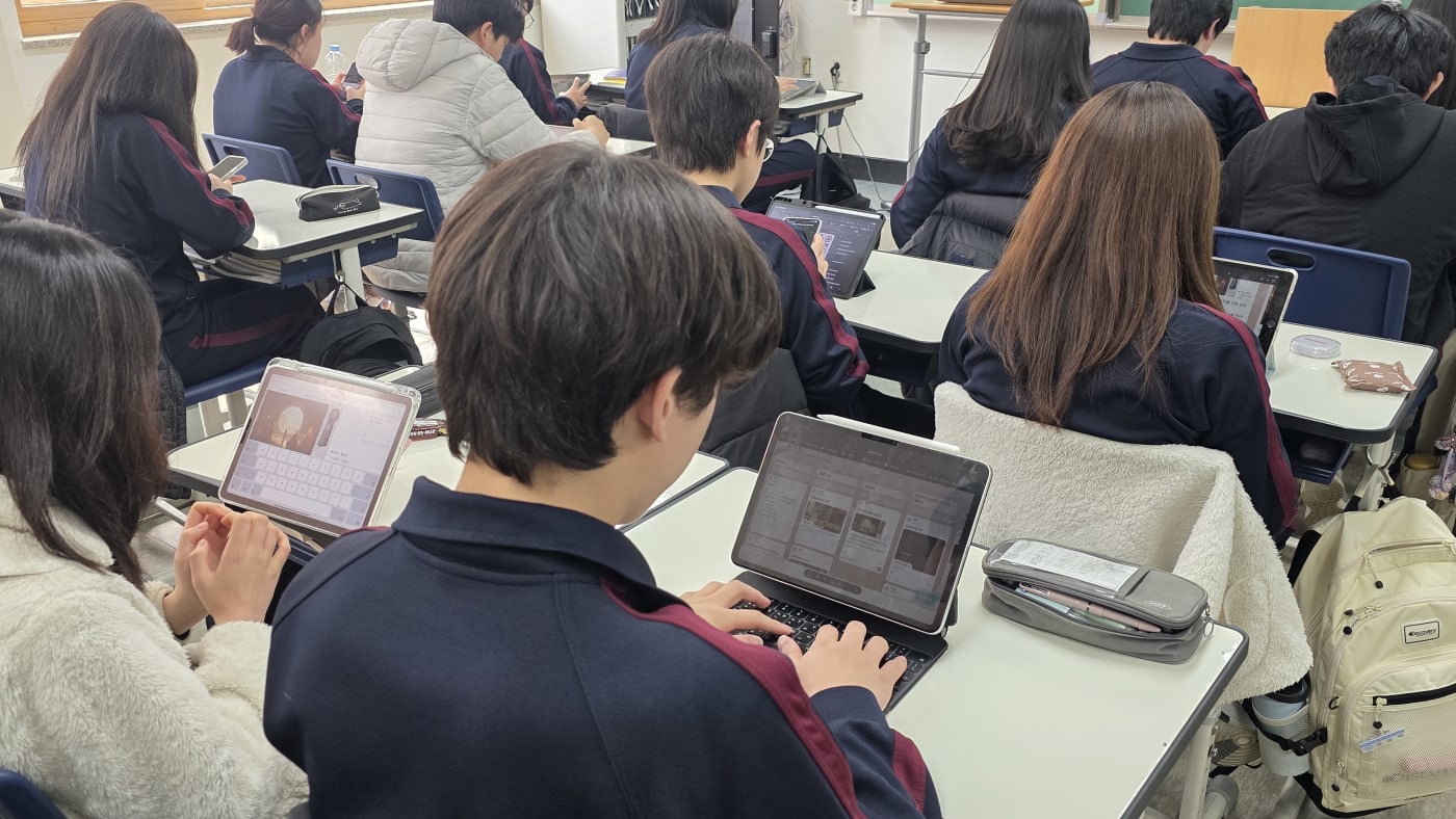 키보드가 장착된 태블릿으로 바이브코딩 실습을 하며 논리적 사고를 키우는 학생의 뒷모습입니다.