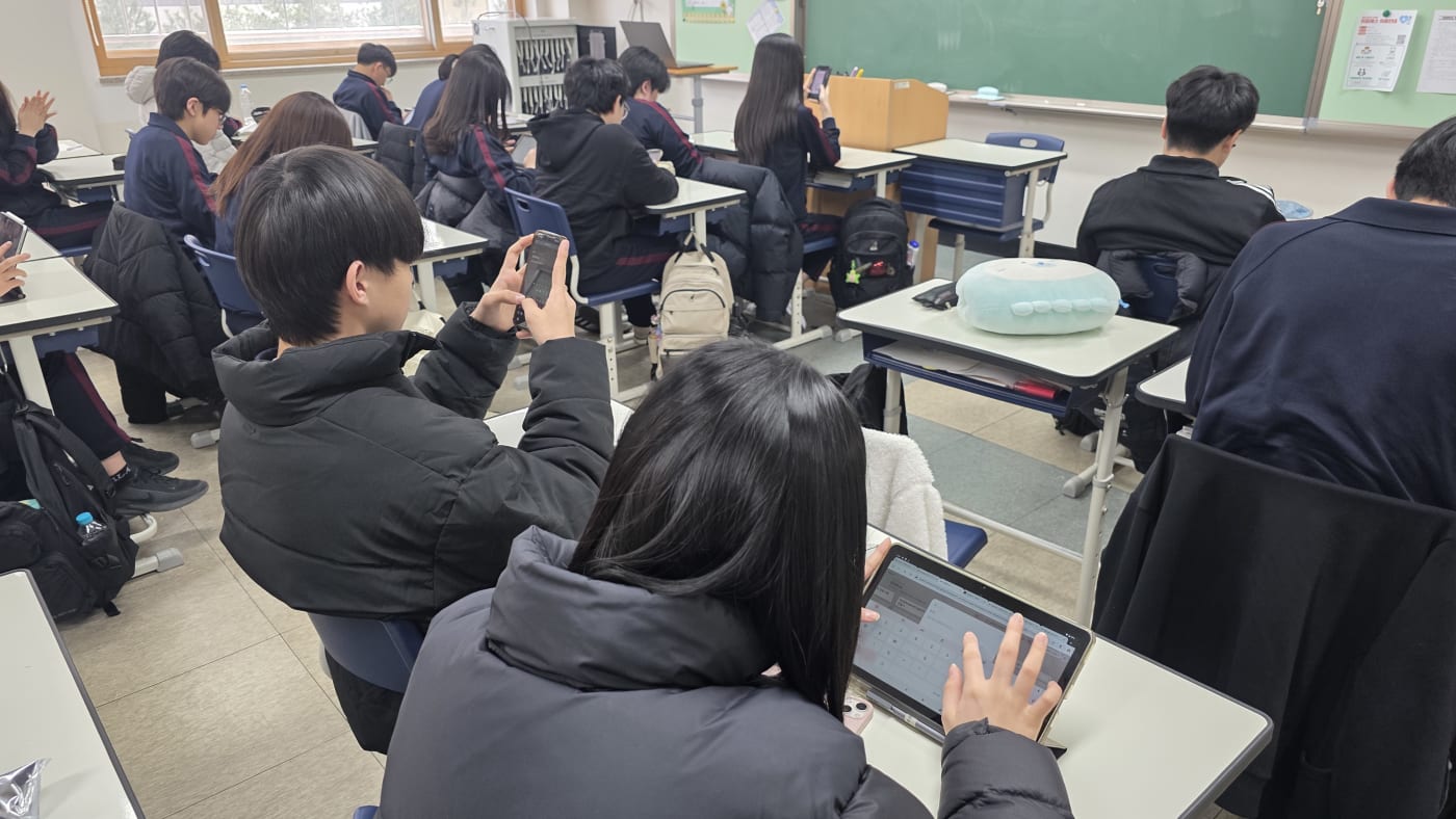 태블릿을 통해 프롬프트 엔지니어링 실습을 하거나 학습 도구로 활용하는 학생들의 역동적인 모습입니다.