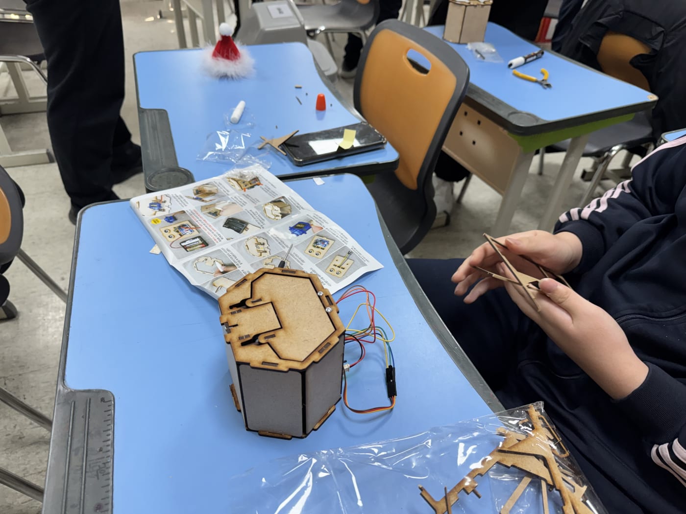 학생의 손이 복잡한 배선 작업을 마무리하고 있는 모습