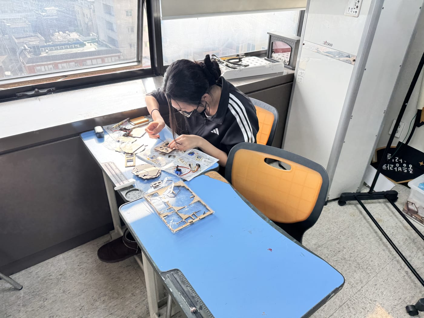 한 학생이 매뉴얼을 보며 초음파 센서를 정밀하게 장착하고 있다.