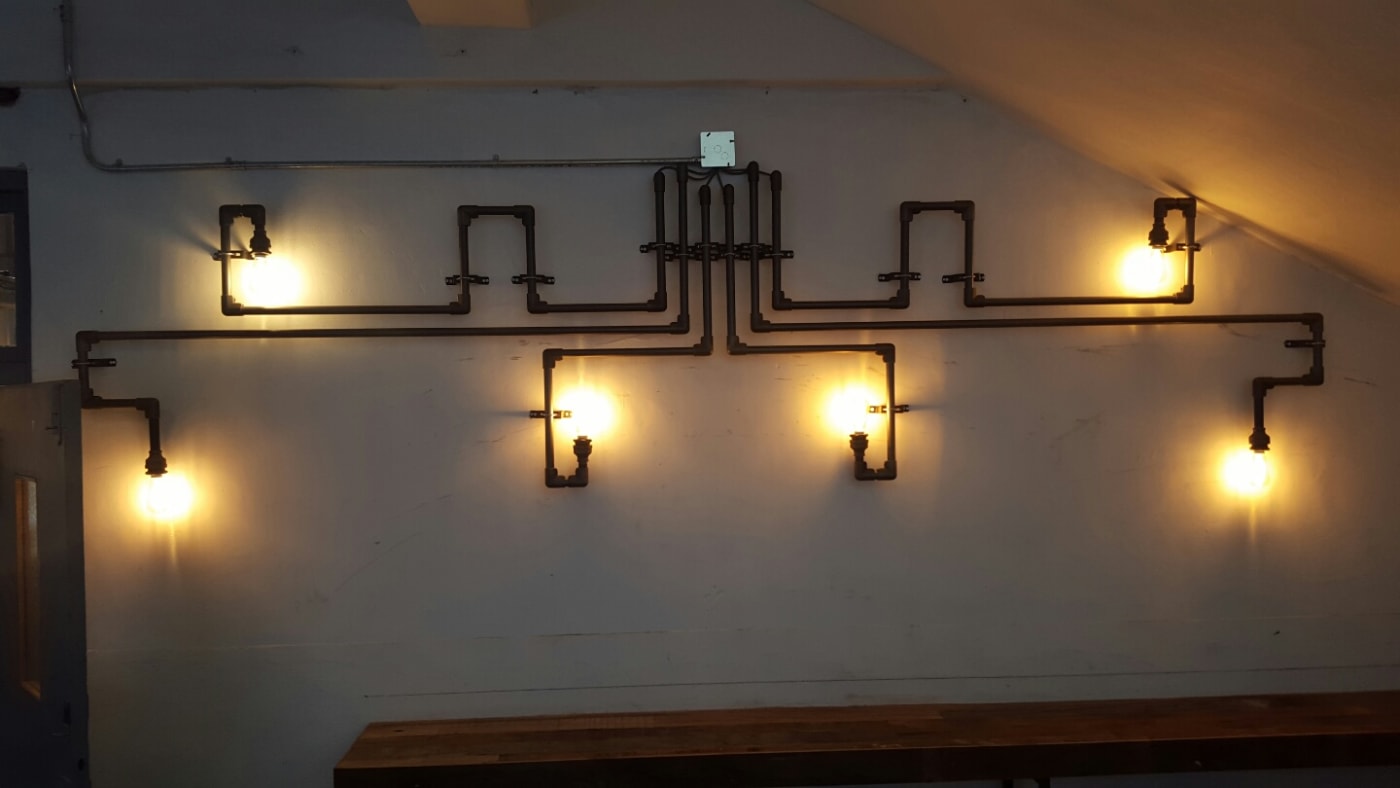 블랙 파이프와 에디슨 전구를 결합한 벽면 조명 인테리어입니다. 파이넥트의 정밀한 조인트 기술을 통해 별도의 용접 없이도 복잡한 각도의 구조를 예술적으로 구현한 것이 특징입니다.