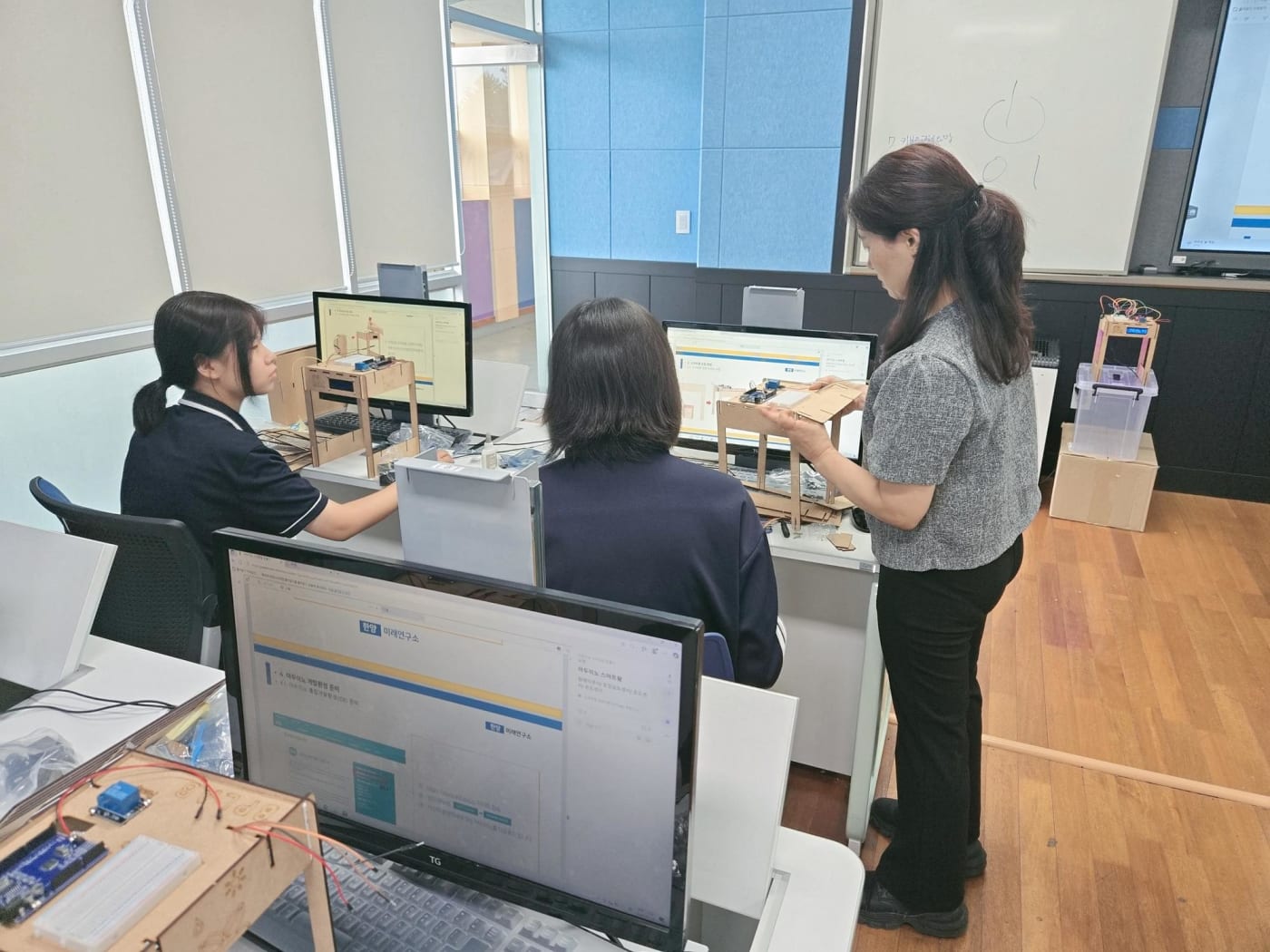 한양미래연구소 로고가 보이는 모니터 앞에서 강사가 학생들에게 하드웨어 키트 조립법을 지도하고 있는 장면입니다.