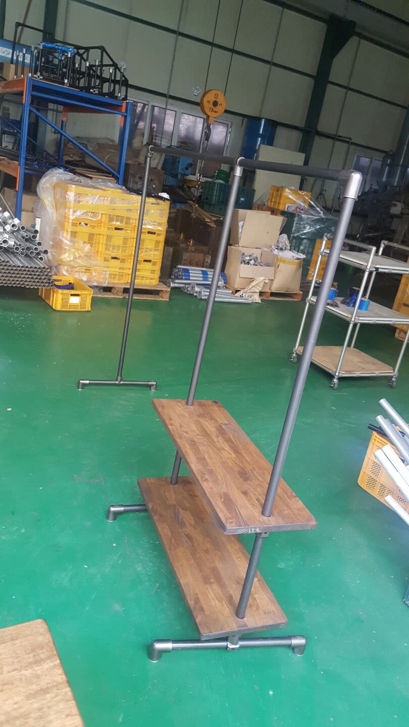 내추럴한 원목 상판과 인더스트리얼한 파이프 프레임이 결합된 2단 선반 행거입니다. 파이넥트 피팅을 활용해 용접 없이 견고하게 제작되어, 매장 디스플레이나 워크숍 공간에서 세련된 전시 구조물로 활용하기 좋습니다.