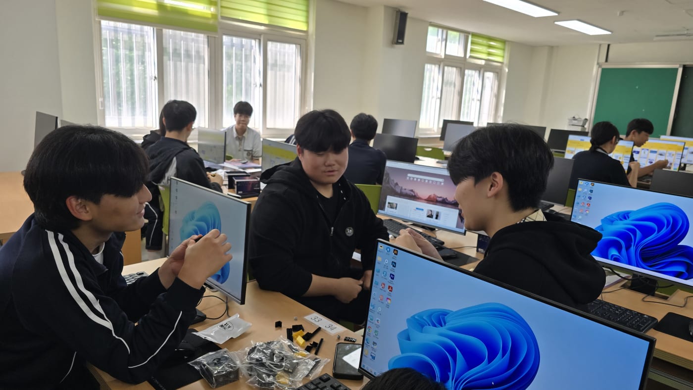 학생들이 작은 부품 하나하나를 세심하게 살피며 아이블 AI 로봇을 정교하게 조립하고 있다.