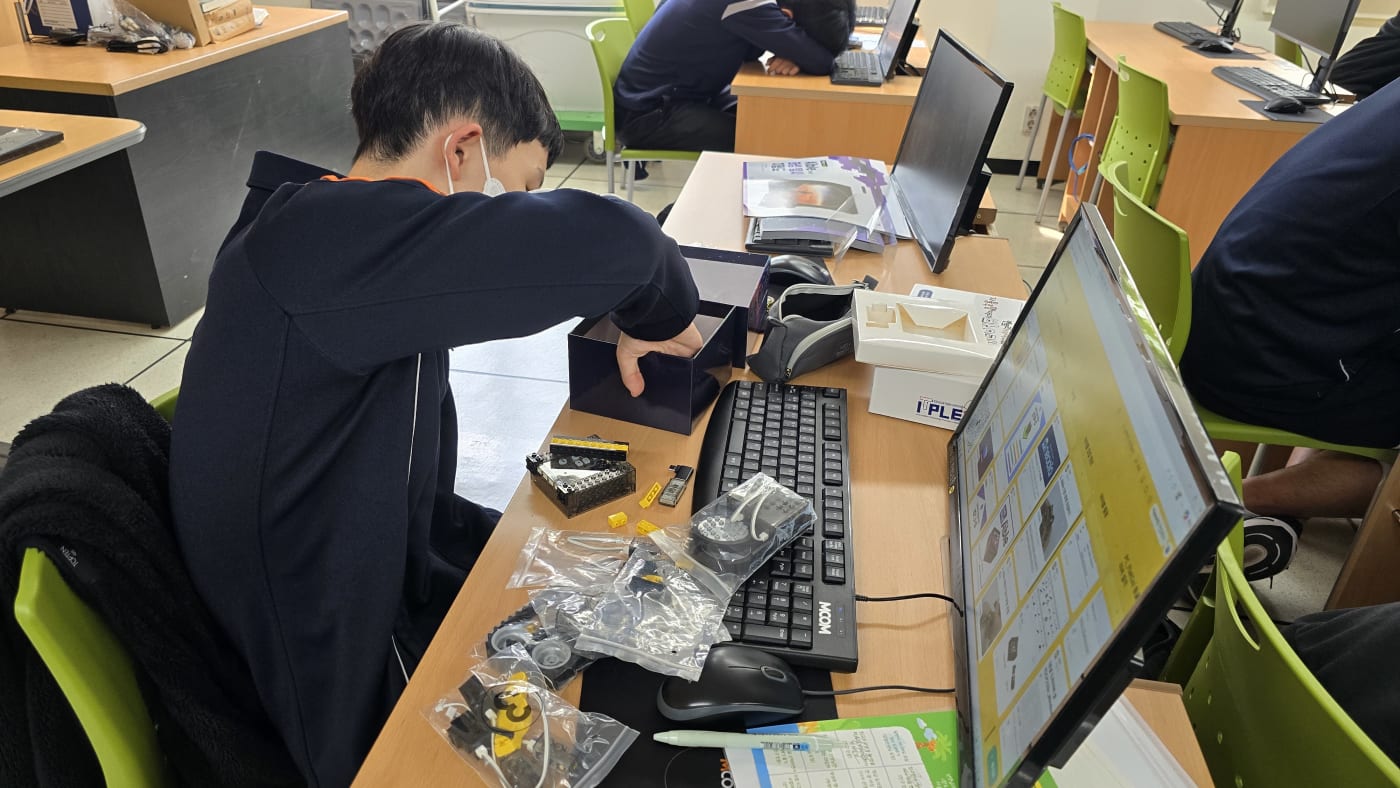 새로운 도전에 대한 설렘으로 아이블 로봇 키트 박스를 열어 조립을 시작하는 학생의 모습
