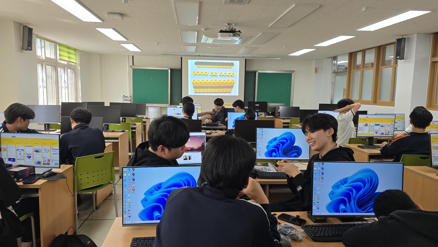 팀원들이 서로의 모니터를 함께 보며 코딩 오류를 수정하는 등 즐겁게 협업하고 있다.