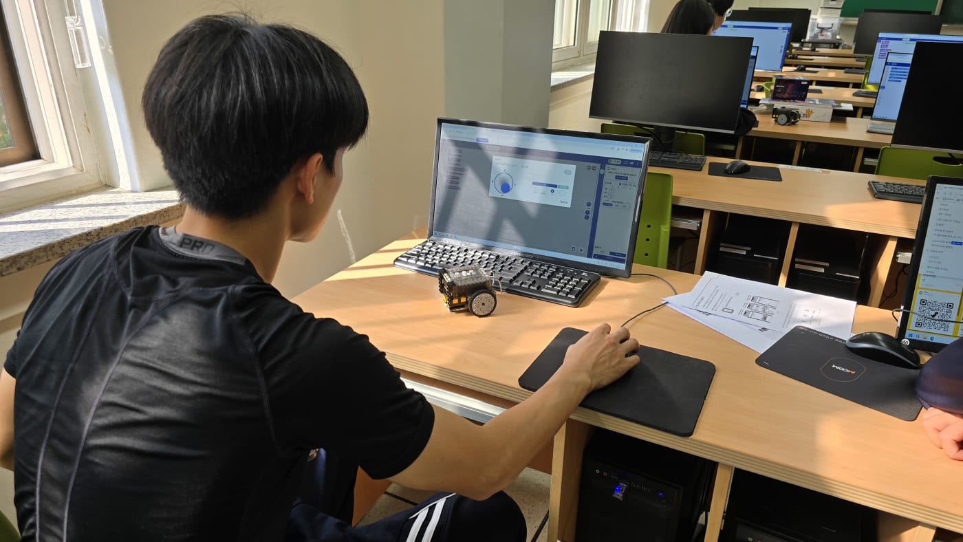학생이 직접 작성한 코드가 아이블 로봇의 움직임에 즉각적으로 반영되는 것을 확인하고 있다.