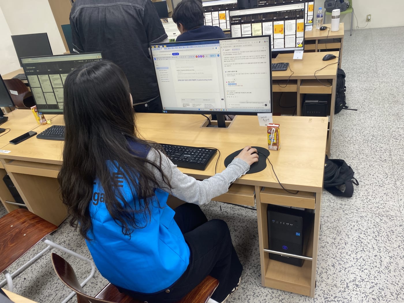 멘토가 학생 옆에서 바이올린 플롯 같은 통계 분석 기법을 1:1로 지도하고 있다.