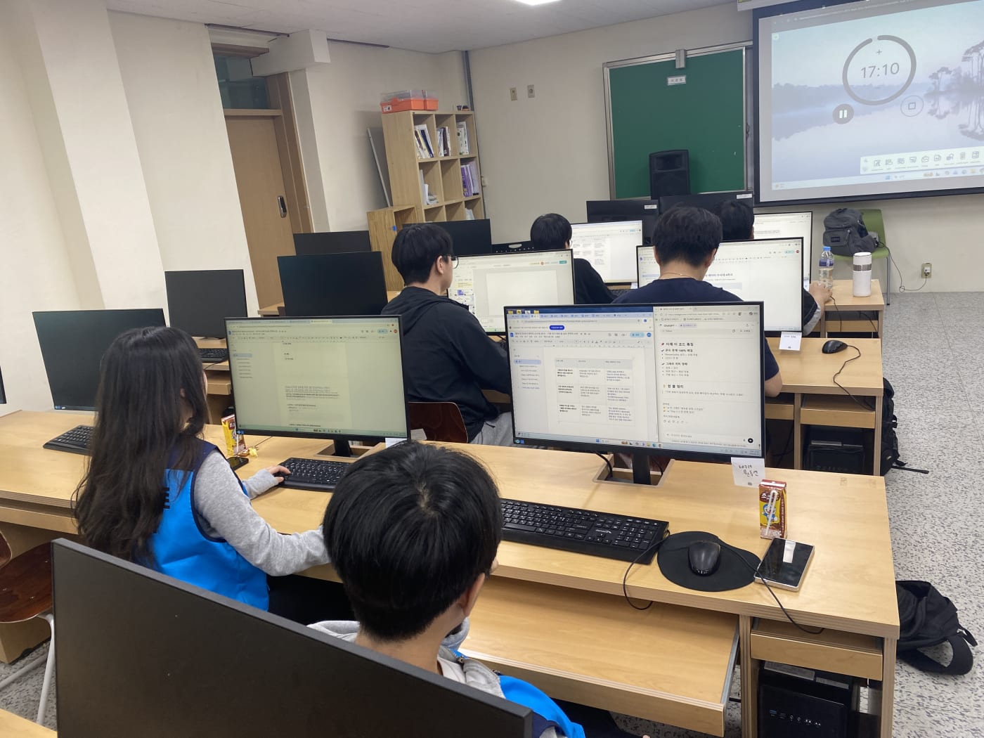 타이머가 켜진 화면 앞에서 학생들이 발표 자료 준비에 몰입하고 있는 역동적인 모습