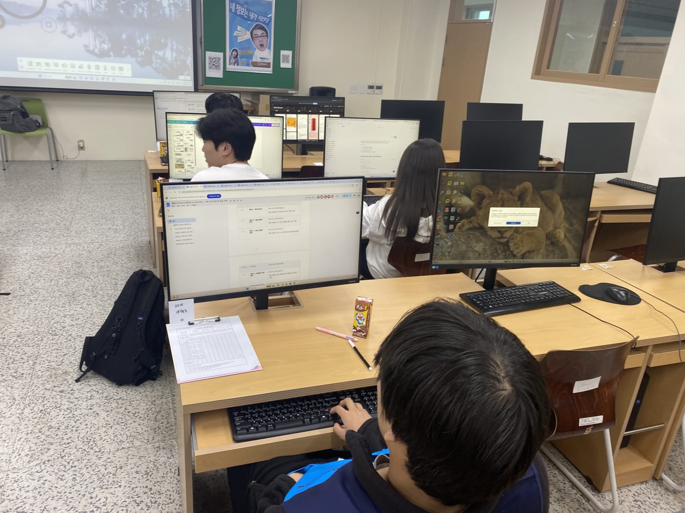 학생들이 각자 자리에 앉아 기후 데이터 분석 리포트를 작성하며 집중하고 있는 모습