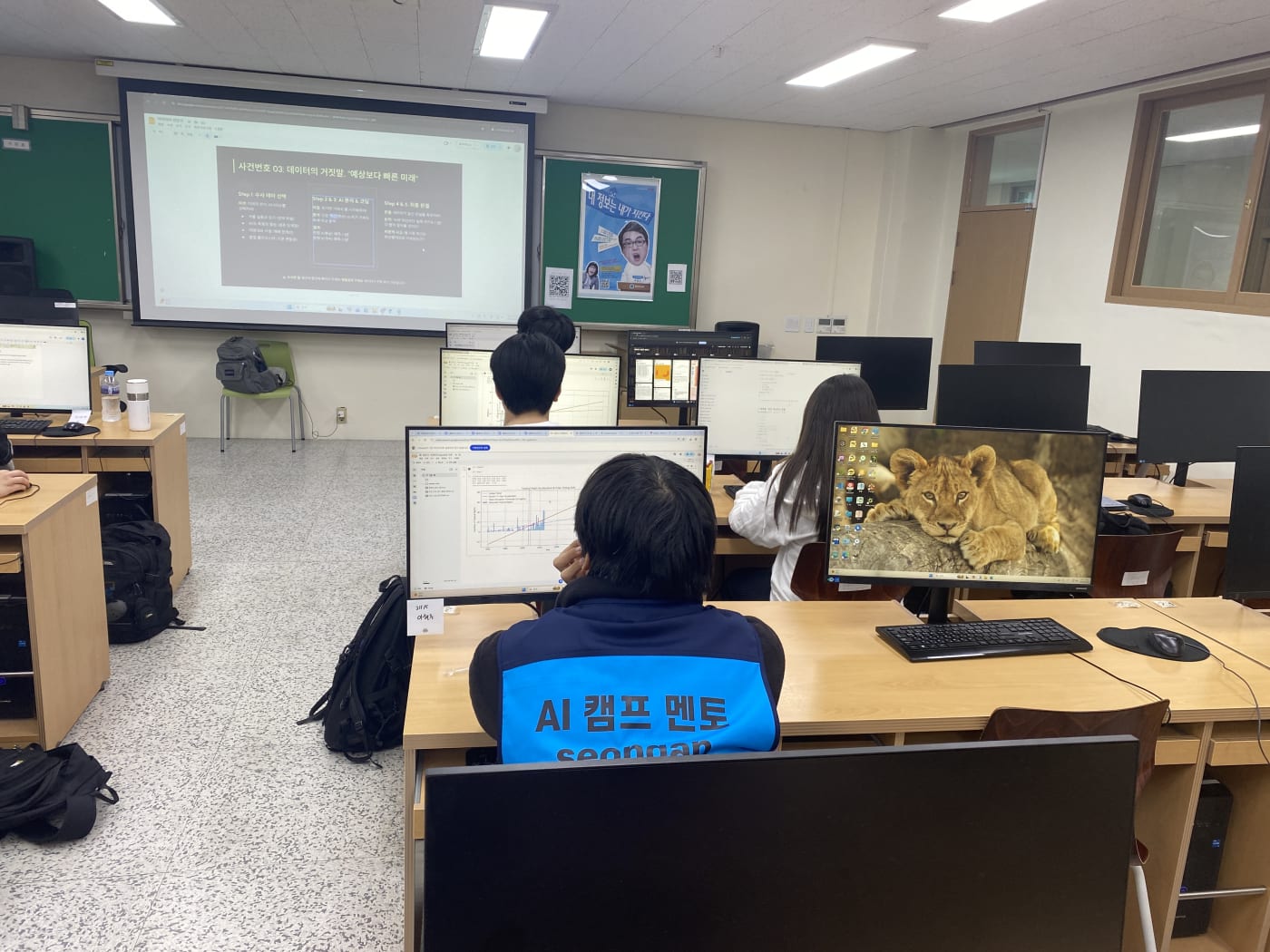 멘토가 학생 뒤에서 완성된 예측 모델 차트를 꼼꼼하게 검토하며 피드백해주고 있다.