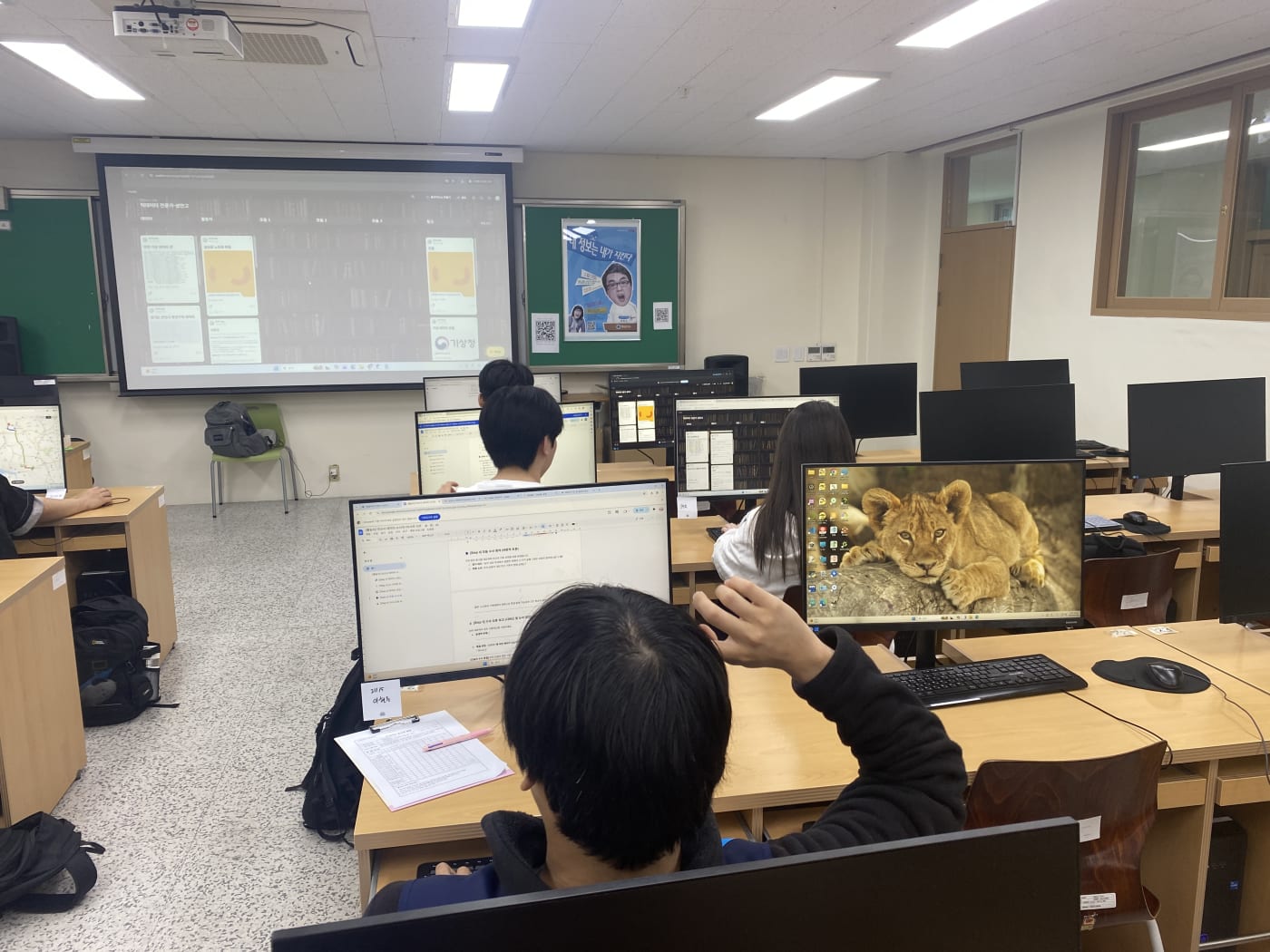 대형 스크린의 분석 프로세스를 보며 각자 PC로 데이터 모델링을 준비하는 학생들