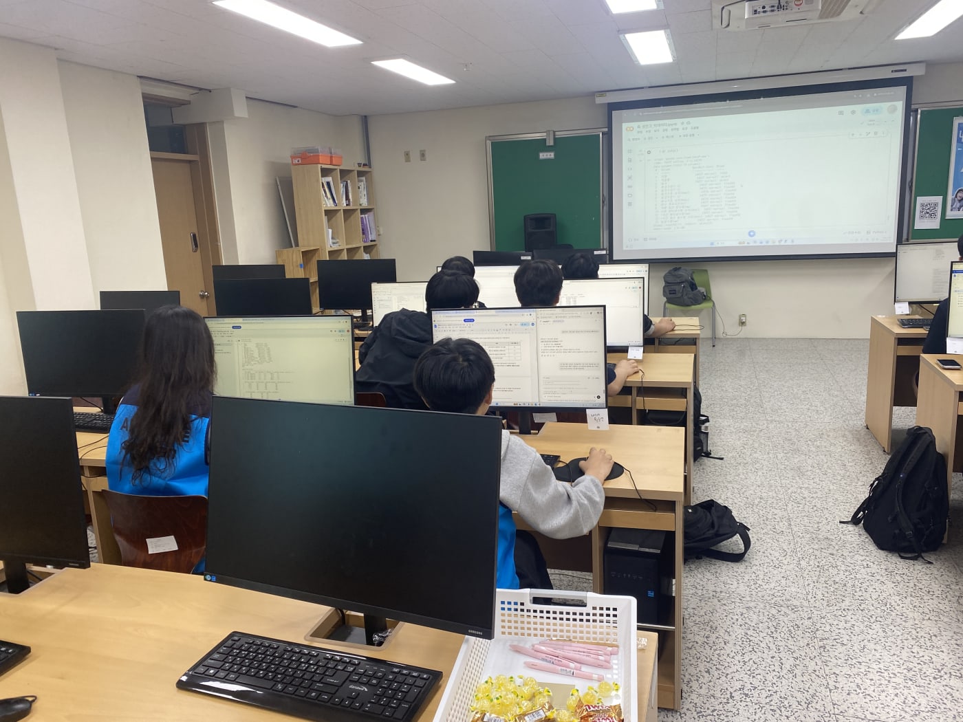 전면 스크린의 가이드를 보며 실시간으로 코드를 실행하고 결과물을 확인하는 학생